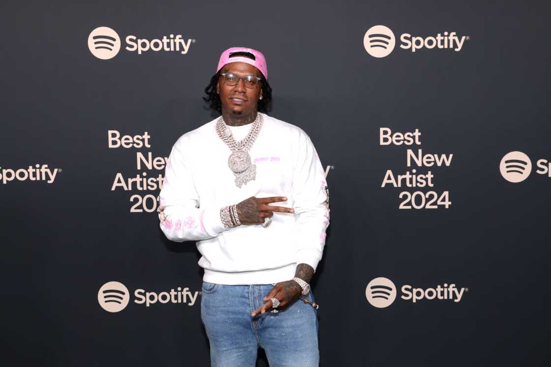 Moneybagg Yo in a white sweat shirt and blue jeans Moneybagg Yo in a white sweat shirt and blue jeans