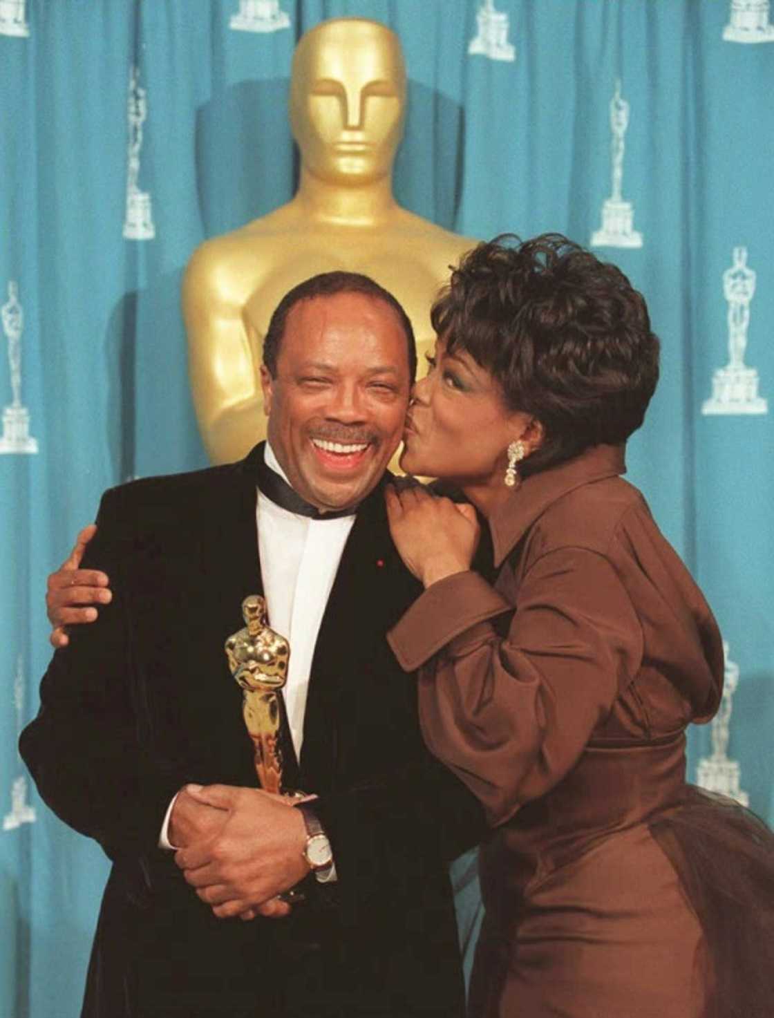 US TV talk show host Oprah Winfrey kisses Jones during the 67th Academy Awards in Los Angeles, after he received an award for his humanitarian work