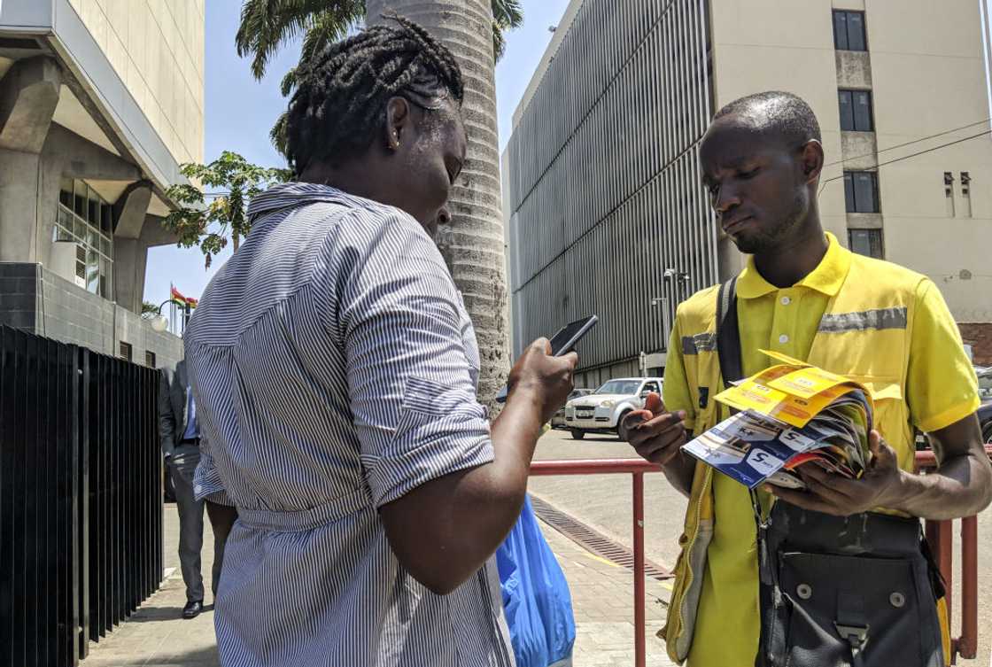 Two people transacting in the streets of Ghana. Two people transacting in the streets of Ghana.