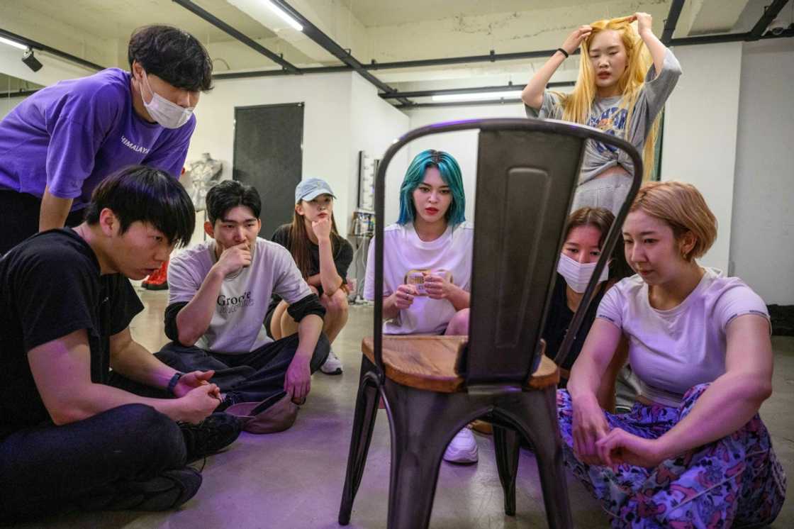 K-pop star AleXa (C) and her dance crew watch mobile phone footage of their rehearsal K-pop star AleXa (C) and her dance crew watch mobile phone footage of their rehearsal