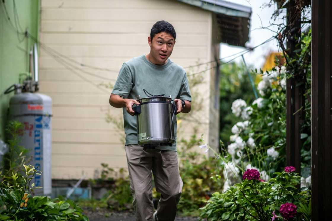 Koichi Miyatsu, 18, carries a pot from his home to a church as part of a monthly charity event for underprivileged children Koichi Miyatsu, 18, carries a pot from his home to a church as part of a monthly charity event for underprivileged children