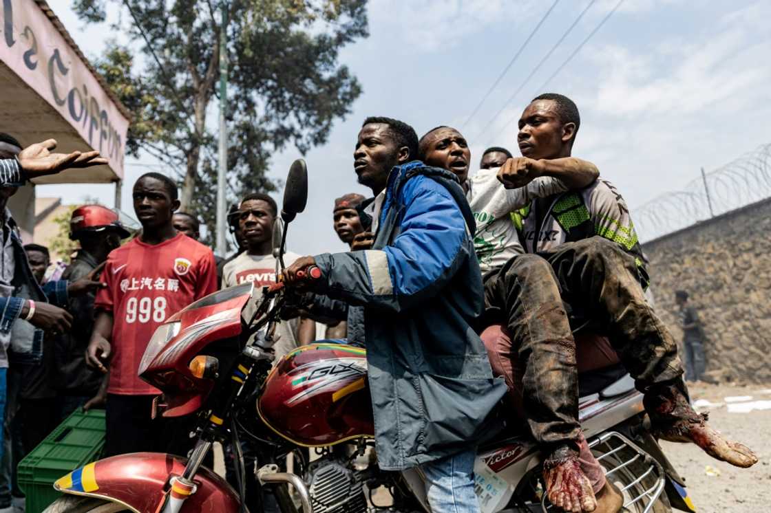 An injured man was taken away on a motorbike during Monday's protests at the UN's warehouse in Goma An injured man was taken away on a motorbike during Monday's protests at the UN's warehouse in Goma