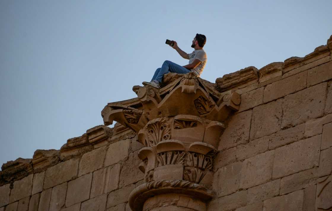 The tourists were taking selfies in front of impressive colonnades with Corinthian capitals The tourists were taking selfies in front of impressive colonnades with Corinthian capitals