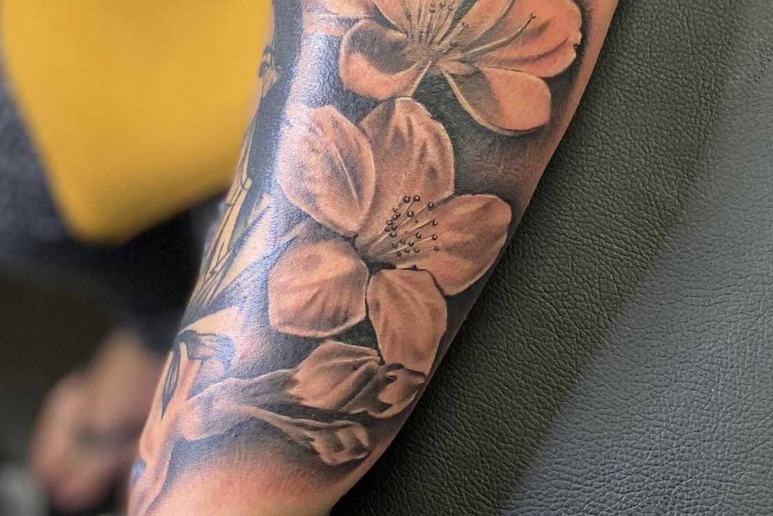 A person wears a blossom tattoo design