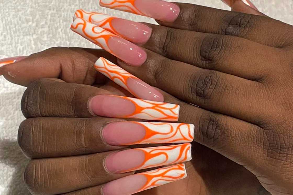 Swirly orange French nail design Swirly orange French nail design