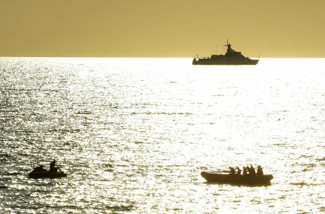 In Sevastopol, Crimea's largest city and home to the Russian Black Sea fleet, Russian warships are visible as beachgoers cool off in the sea