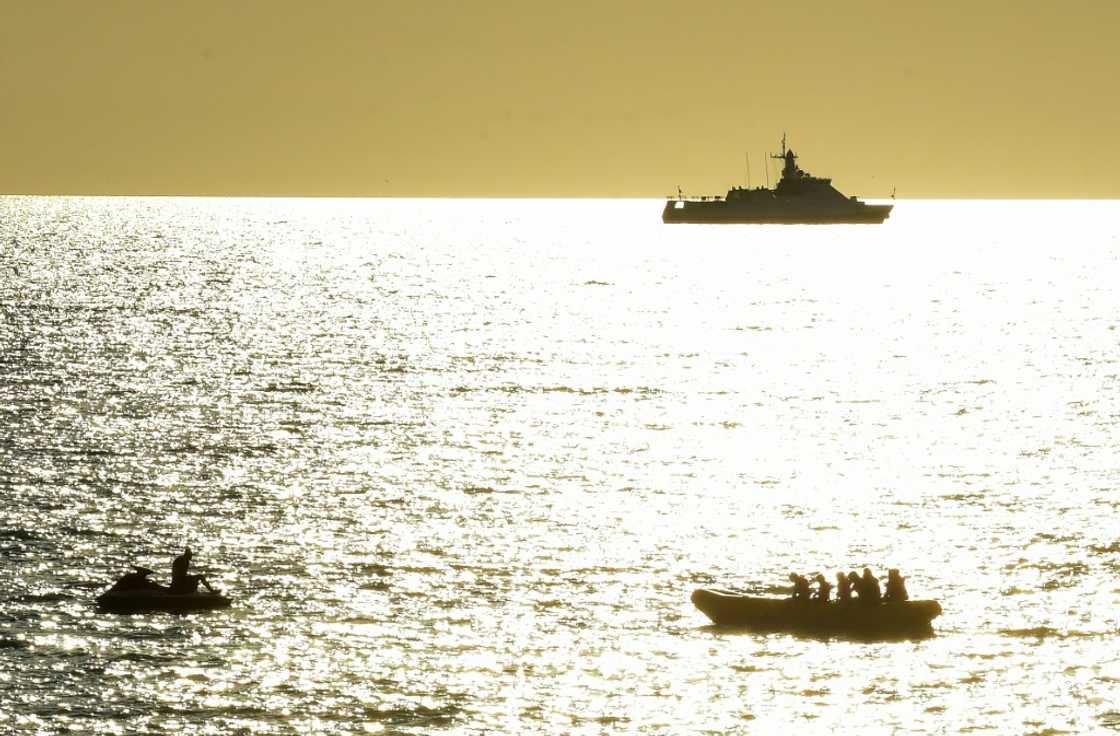 In Sevastopol, Crimea's largest city and home to the Russian Black Sea fleet, Russian warships are visible as beachgoers cool off in the sea In Sevastopol, Crimea's largest city and home to the Russian Black Sea fleet, Russian warships are visible as beachgoers cool off in the sea