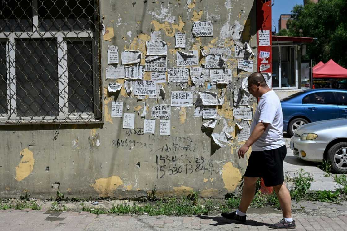 A man walks past home rental advertisements in a residential compound in Hegang city in northeastern China's Heilongjiang province A man walks past home rental advertisements in a residential compound in Hegang city in northeastern China's Heilongjiang province