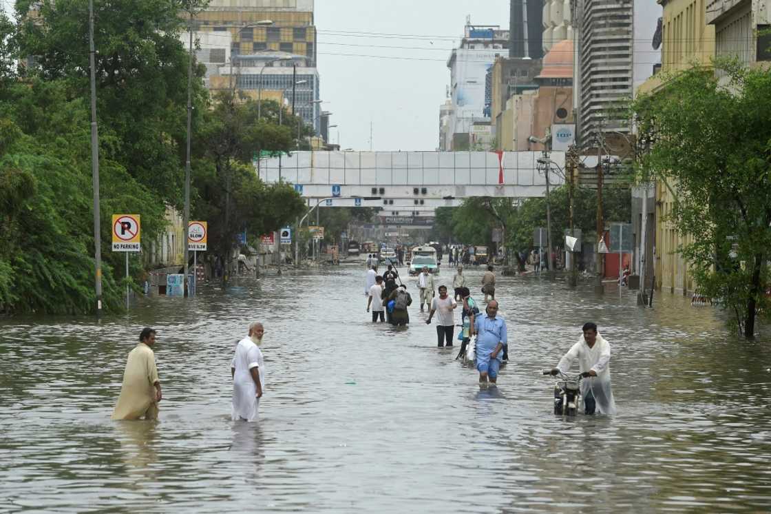 People wade across a flooded street in Karachi People wade across a flooded street in Karachi