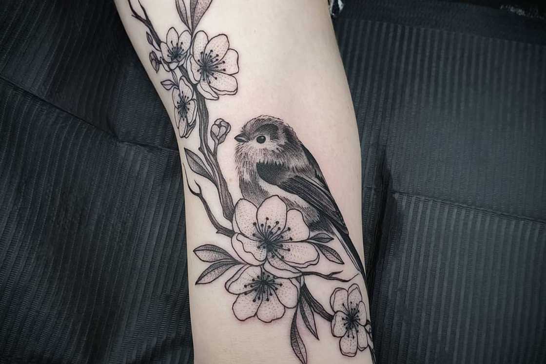 A black and white cherry blossom bird tattoo