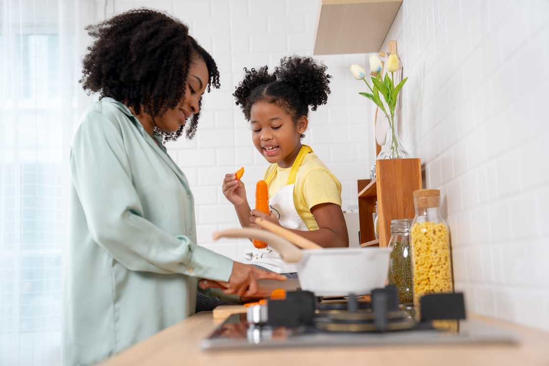Mom and daughter have fun cooking in the kitchen.