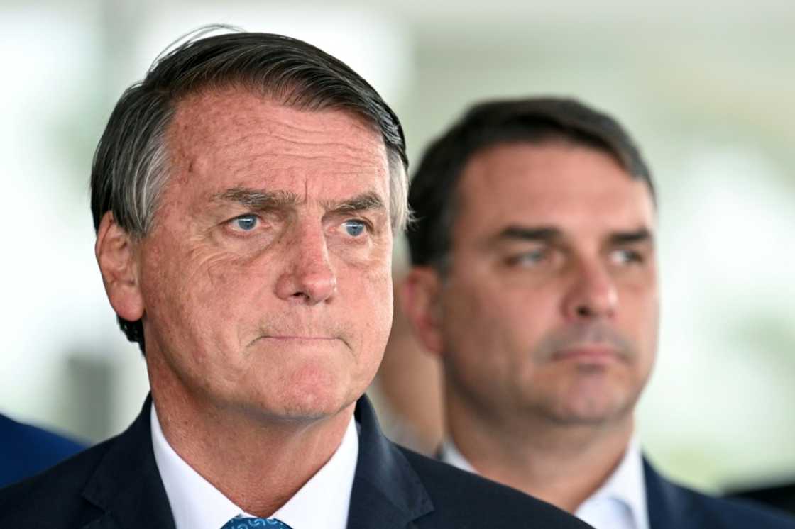 Brazilian President and re-election candidate Jair Bolsonaro (L) listens to questions next to his son Flavio during a press conference at Planalto Palace in Brasilia, on October 4, 2022 Brazilian President and re-election candidate Jair Bolsonaro (L) listens to questions next to his son Flavio during a press conference at Planalto Palace in Brasilia, on October 4, 2022