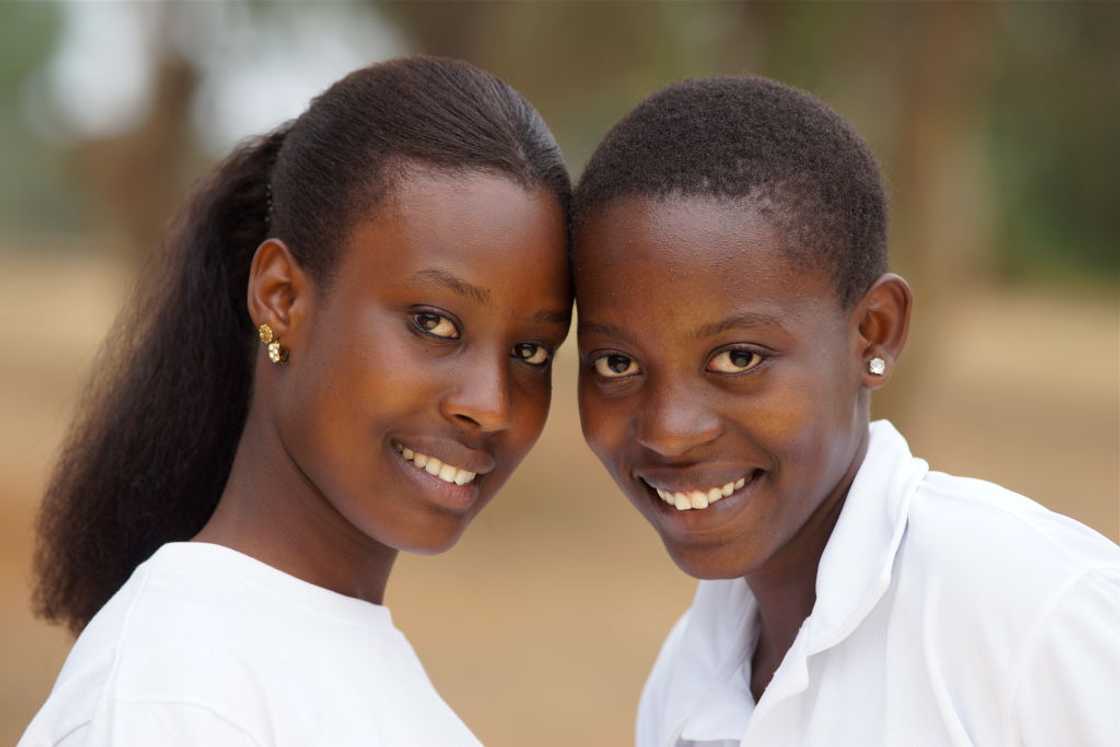 Two girlfriends wearing school uniforms looking at the camera