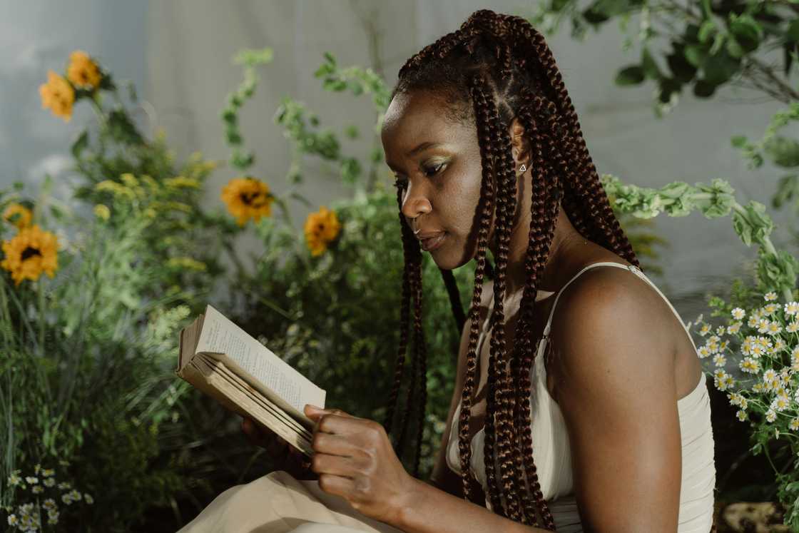 A young woman with braided hair reading a book A young woman with braided hair reading a book