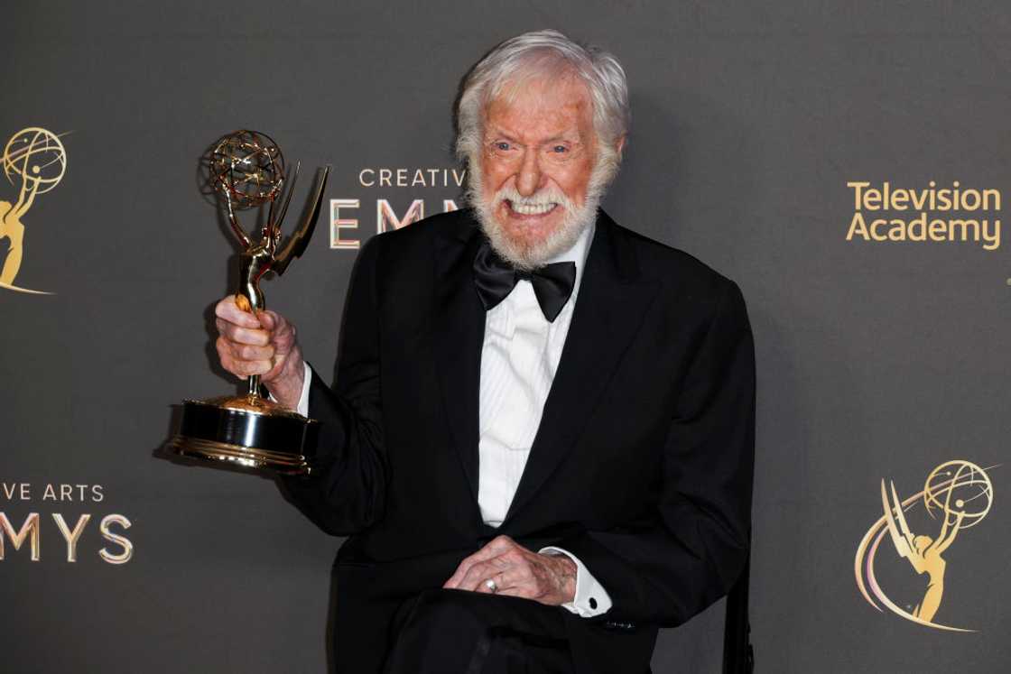 Dick Van Dyke in a black suit holding an award Dick Van Dyke in a black suit holding an award