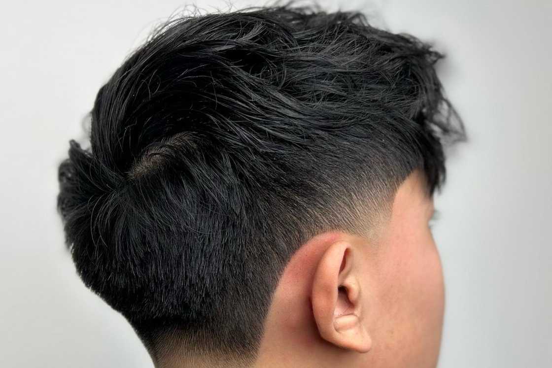 An Asian boy is rocking a soft taper fade with a front fringe An Asian boy is rocking a soft taper fade with a front fringe