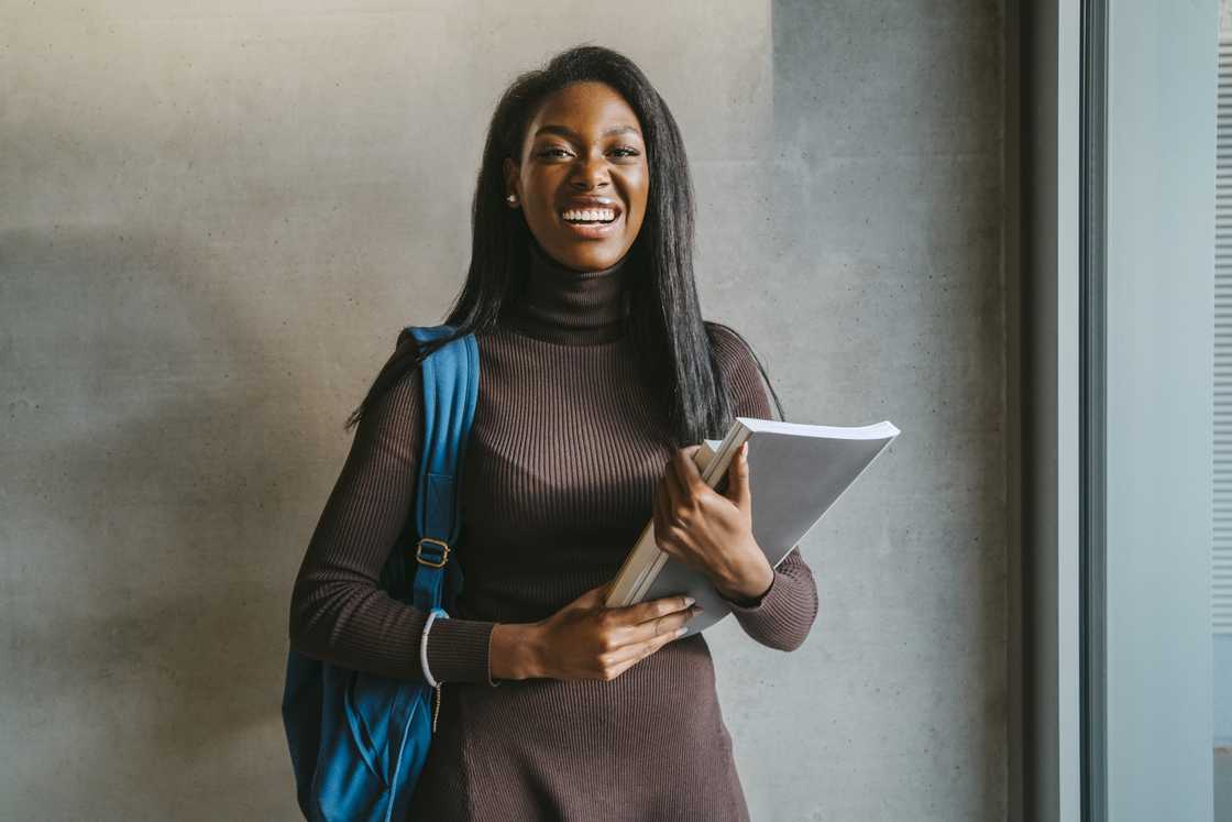 A cheerful student carrying books