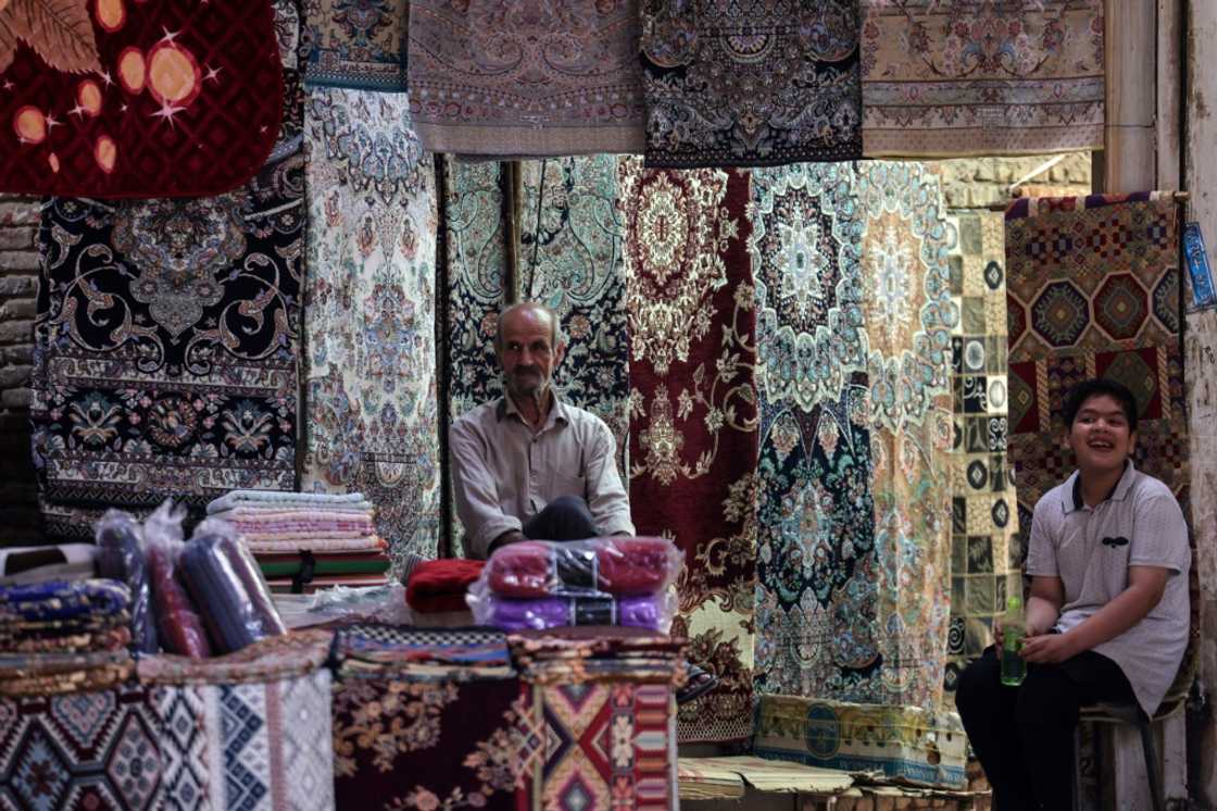 A rug vendor waits for customers in the old market of Iran's central city of Yazd A rug vendor waits for customers in the old market of Iran's central city of Yazd
