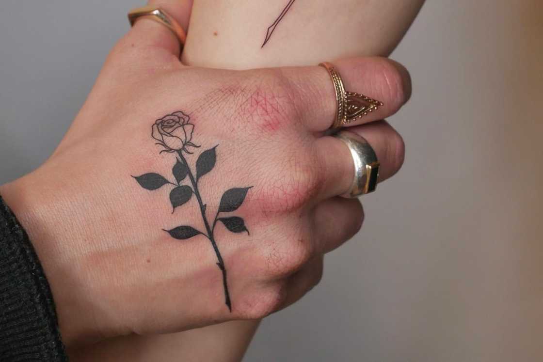 A simple fineline rose hand tattoo A simple fineline rose hand tattoo