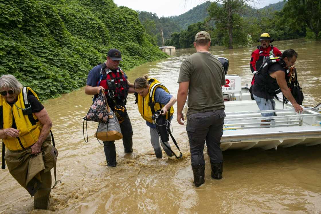 Members of a rescue team assist a family out of a boat in Quicksand, Kentucky, after flash floods Members of a rescue team assist a family out of a boat in Quicksand, Kentucky, after flash floods