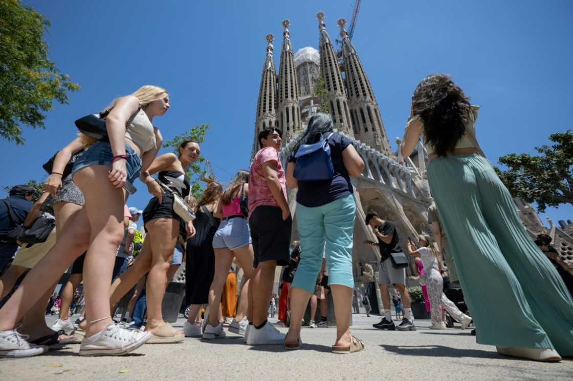 Tourists stand in front of the Sagrada Familia basilica in Barcelona on July 5, 2024 Tourists stand in front of the Sagrada Familia basilica in Barcelona on July 5, 2024