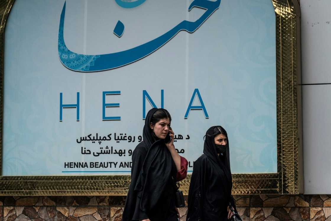 Women walk past a beauty salon in the Shahr-e-Naw area of Kabul ahead ahead of the order for beauty parlours across the country to shut permanently Women walk past a beauty salon in the Shahr-e-Naw area of Kabul ahead ahead of the order for beauty parlours across the country to shut permanently