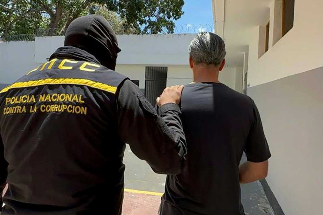 This handout pictured released by the Venezuelan Public Prosecutor's Office on April 9, 2024, shows former Venezuelan oil minister Tareck El Aissami (R) being detained by members of the National Anti-Corruption Police This handout pictured released by the Venezuelan Public Prosecutor's Office on April 9, 2024, shows former Venezuelan oil minister Tareck El Aissami (R) being detained by members of the National Anti-Corruption Police