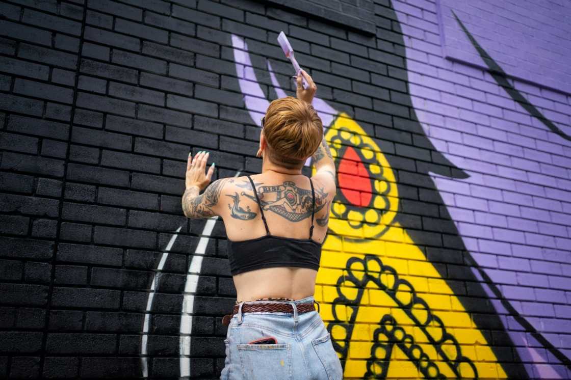 Nikki, an assistant of the artist Hatecopy, paints on a wall during the Mural festival in Montreal, Quebec on June 16, 2022 Nikki, an assistant of the artist Hatecopy, paints on a wall during the Mural festival in Montreal, Quebec on June 16, 2022