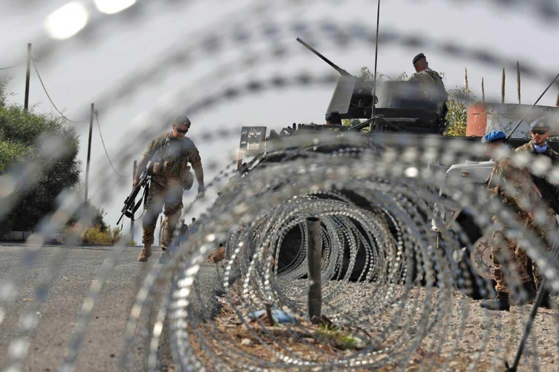 Lebanese army soldiers (L) stand by an infantry-fighting vehicle (IFV) near peacekeepers (R) of the United Nations Interim Force In Lebanon (UNIFIL) in Naqura along the border with northern Israel on Thursday