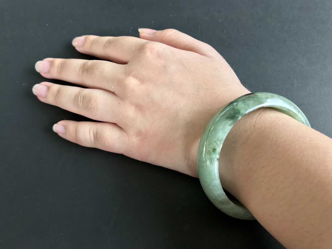 A white woman is wearing a green hololith bracelet A white woman is wearing a green hololith bracelet