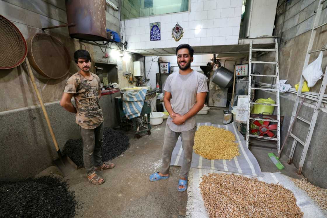 Roaster Majid Ebrahimi (R) and a worker pose for a picture in front of their roasting machine in Tehran's Grand Bazaar Roaster Majid Ebrahimi (R) and a worker pose for a picture in front of their roasting machine in Tehran's Grand Bazaar