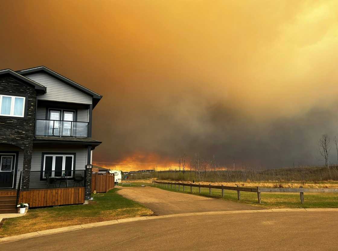 This handout image courtesy of Kosar shows smoke and flames from the fire in Fort McMurray as residents from the Abasand Heights neighborhood evacuate