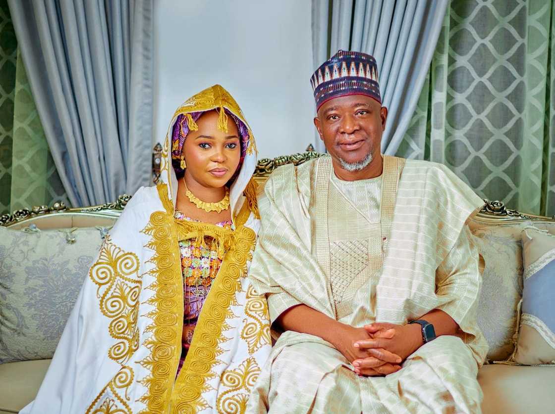 African couple in traditional attire seated together indoors. African couple in traditional attire seated together indoors.