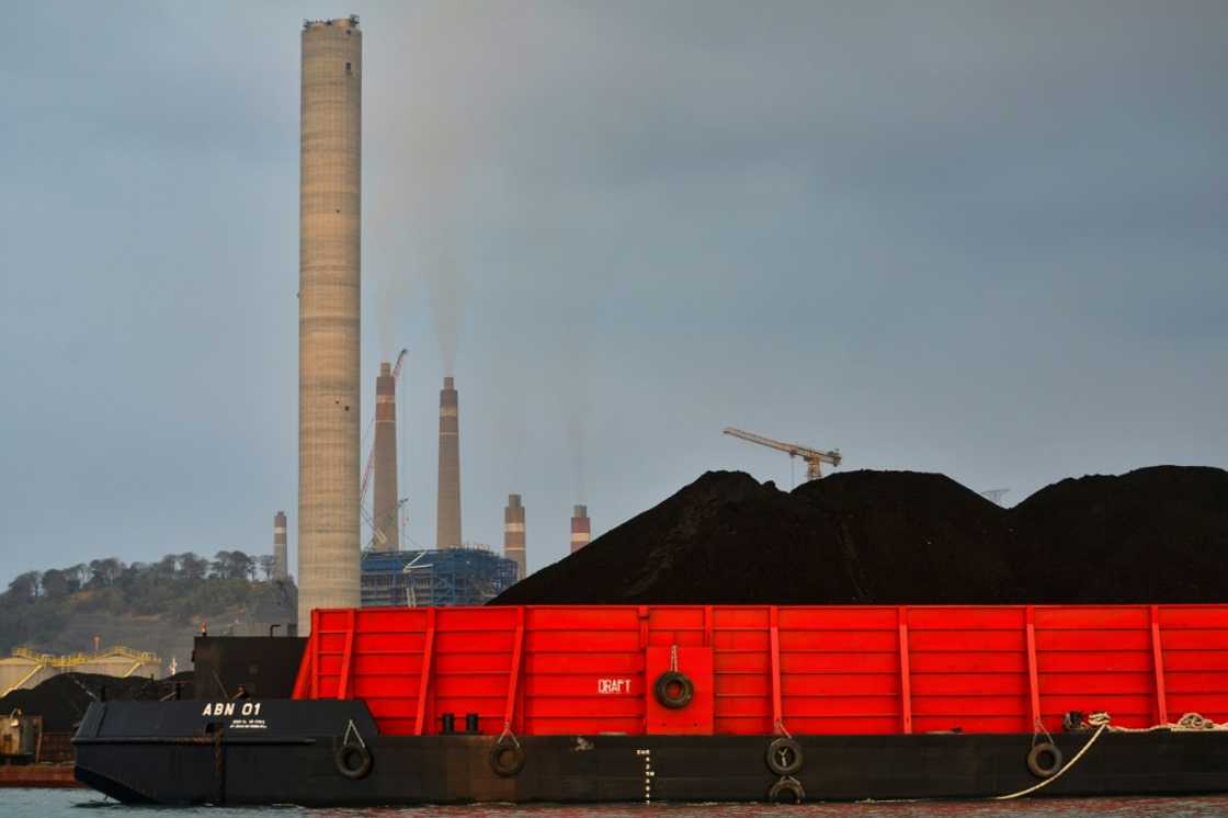 A barge carries coal to the dock next to the Suralaya coal-fired power plant in Cilegon, in Indonesia's Banten province