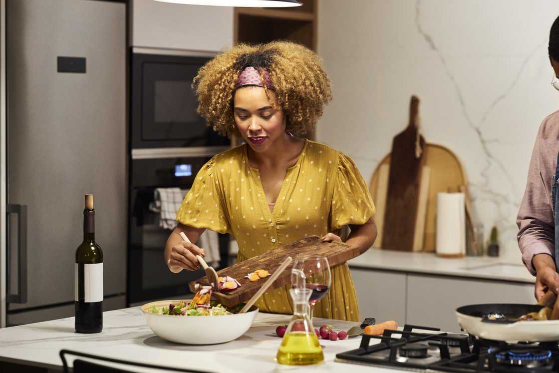 A beautiful woman prepares a healthy salad on the kitchen