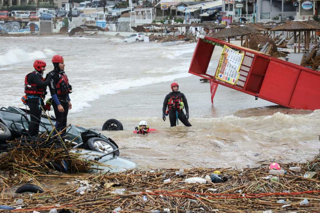 Rescue workers perform a search along the beach of the popular resort of Agia Pelagia, on the southern Greek island of Crete, following flash floods cause by torrential rain, on October 15, 2022 Rescue workers perform a search along the beach of the popular resort of Agia Pelagia, on the southern Greek island of Crete, following flash floods cause by torrential rain, on October 15, 2022