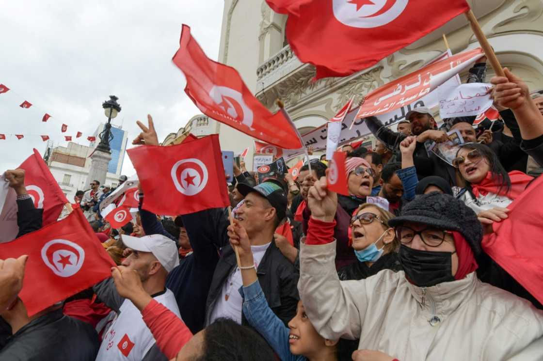 Tunisian demonstrators chant slogans and wave their country's national flag in support of President Kais Saied on May 8