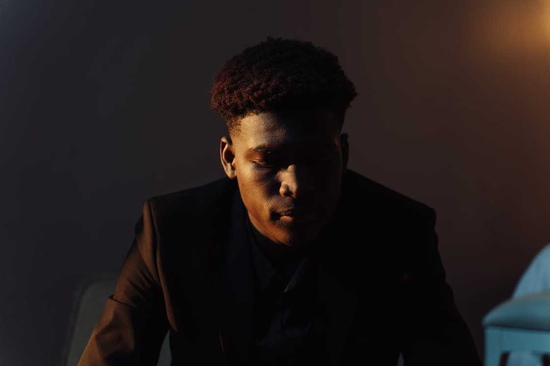 A person uses a smartphone with both hands near a window. A person uses a smartphone with both hands near a window.