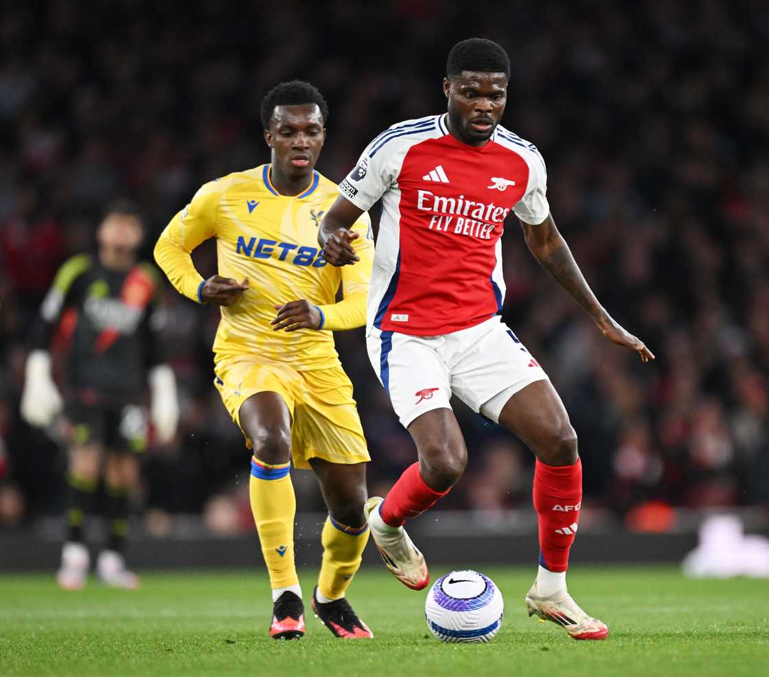 Thomas Partey of Arsenal runs with the ball whilst under pressure from Eddie Nketiah of Crystal Palace during the Premier League match between Arsenal FC and Crystal Palace FC at Emirates Stadium on April 23, 2025 in London, England. Thomas Partey of Arsenal runs with the ball whilst under pressure from Eddie Nketiah of Crystal Palace during the Premier League match between Arsenal FC and Crystal Palace FC at Emirates Stadium on April 23, 2025 in London, England.