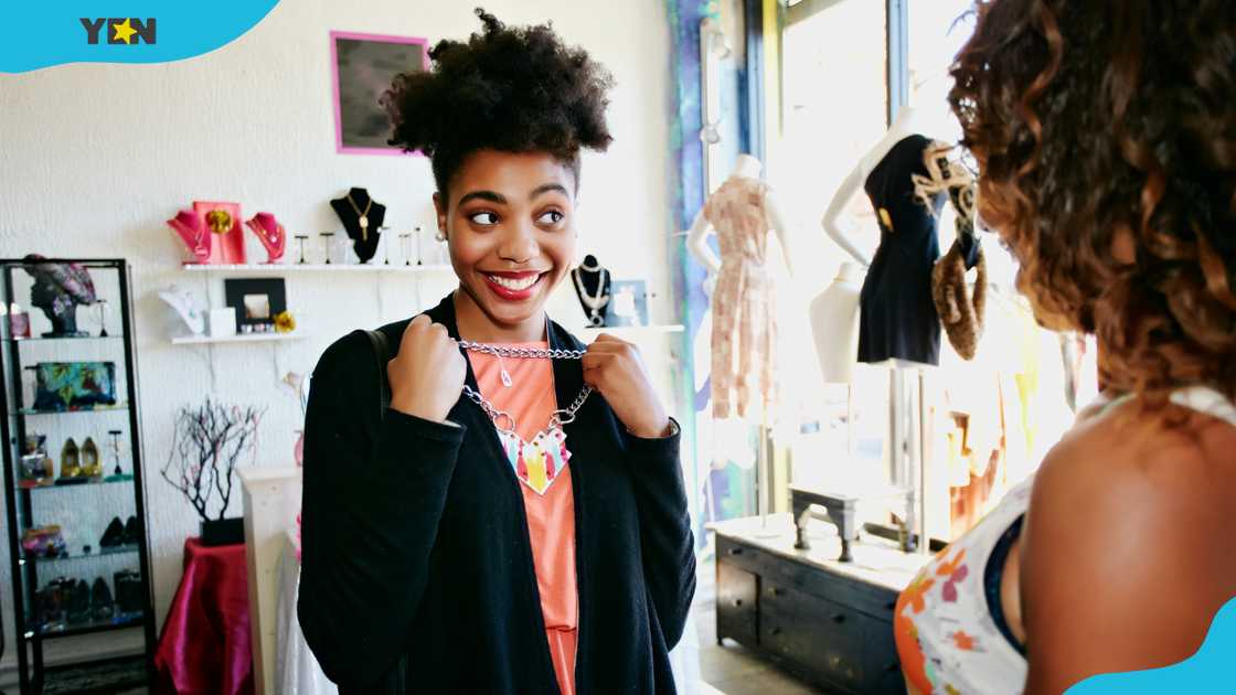 A woman holds a necklace at the store. A woman holds a necklace at the store.