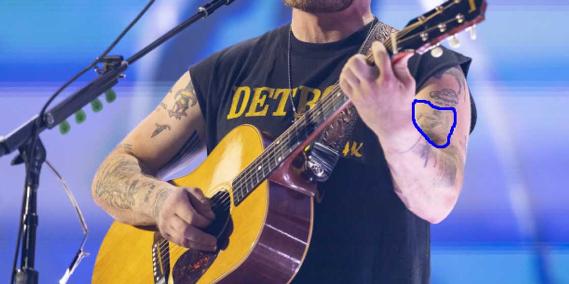 Zach Bryan showcases his "running man" tattoo on his forearm Zach Bryan showcases his "running man" tattoo on his forearm