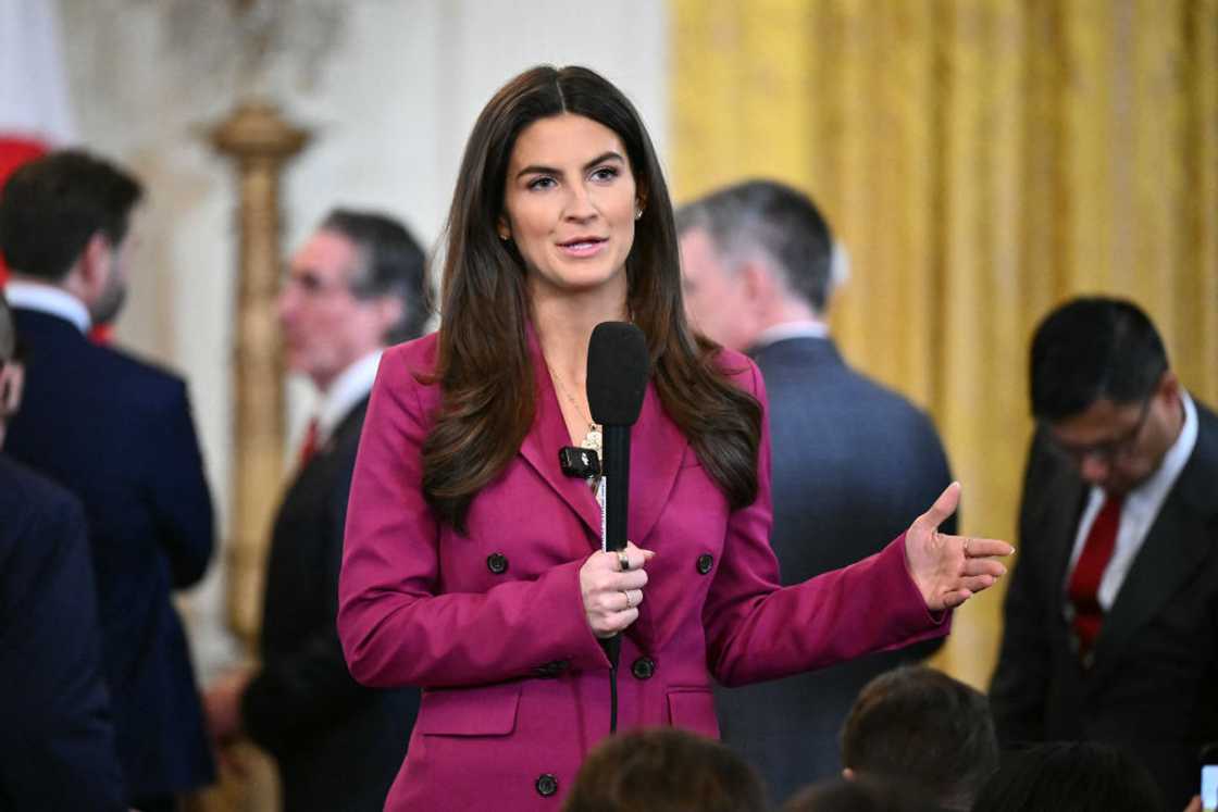 Kaitlan Collins in a purple coat holding a mic Kaitlan Collins in a purple coat holding a mic