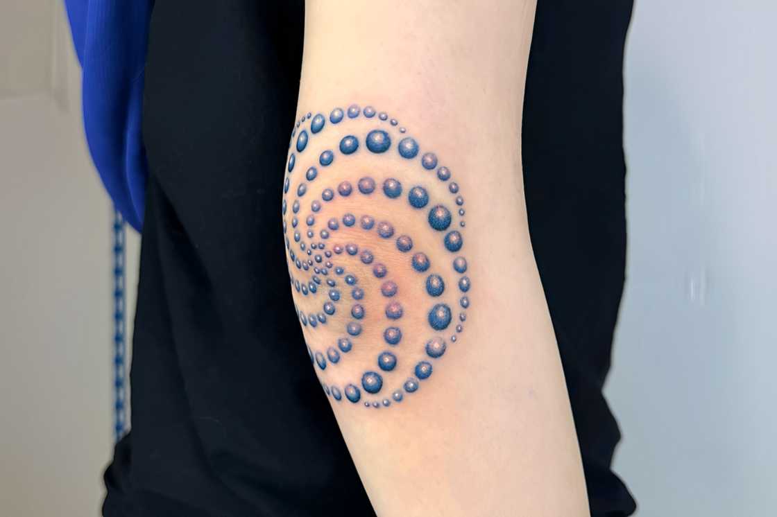 A blue dotwork elbow tattoo A blue dotwork elbow tattoo