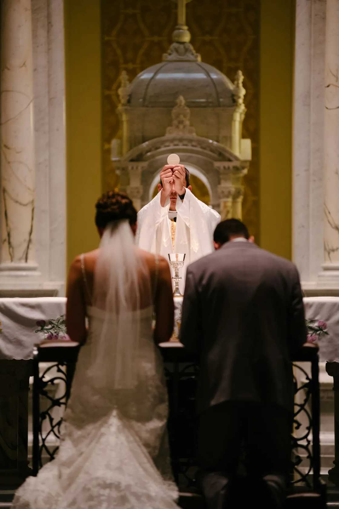 A couple kneeling before a priest