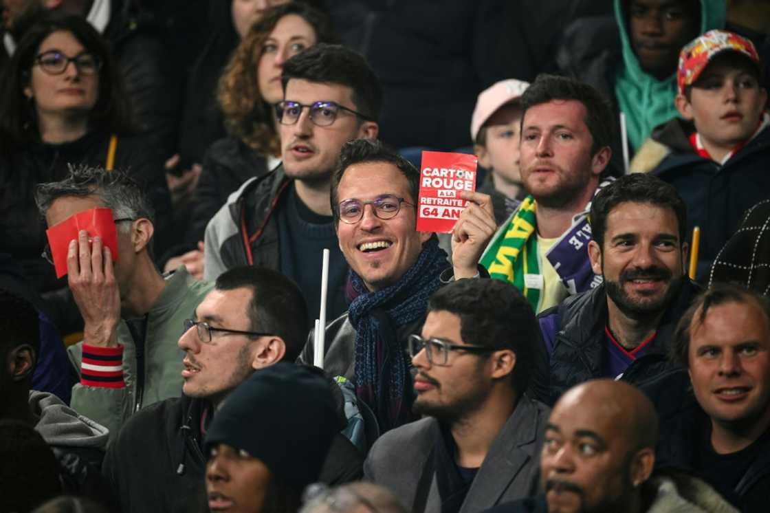 When Macron attended a football match on Saturday, some activists waved red cards at him in protest When Macron attended a football match on Saturday, some activists waved red cards at him in protest