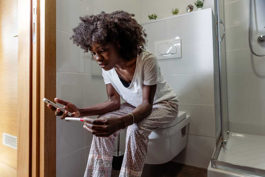 A woman looks at a pregancy test A woman looks at a pregancy test