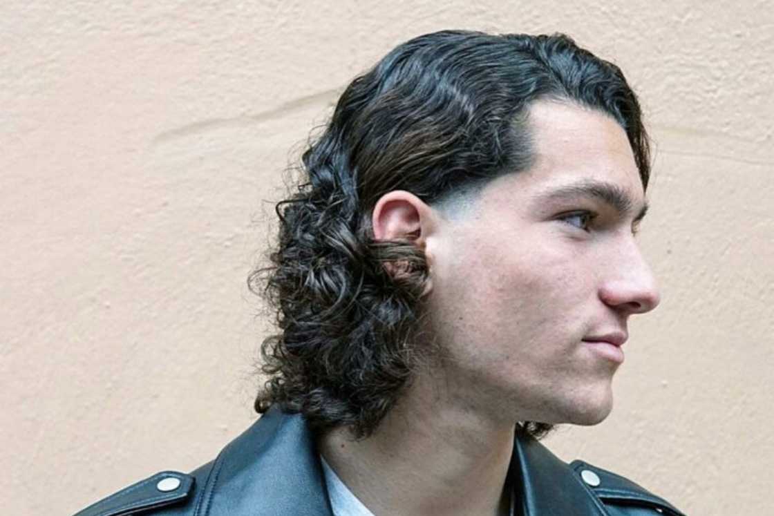 A long curly hair tucked behind the ears A long curly hair tucked behind the ears