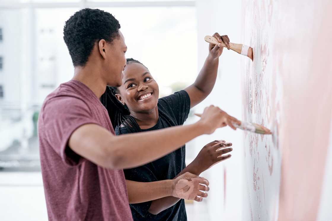 A couple painting their small apartment. A couple painting their small apartment.