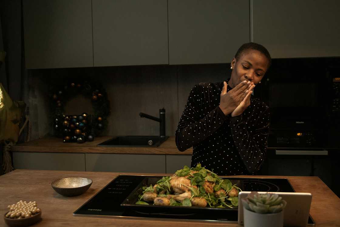 A black woman kissing her hand with a meal in front of her A black woman kissing her hand with a meal in front of her