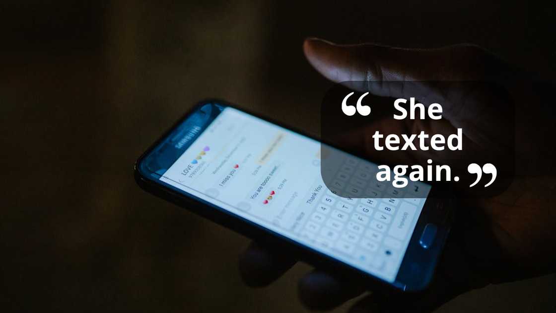 A hand holds a phone displaying text messages in the dark.